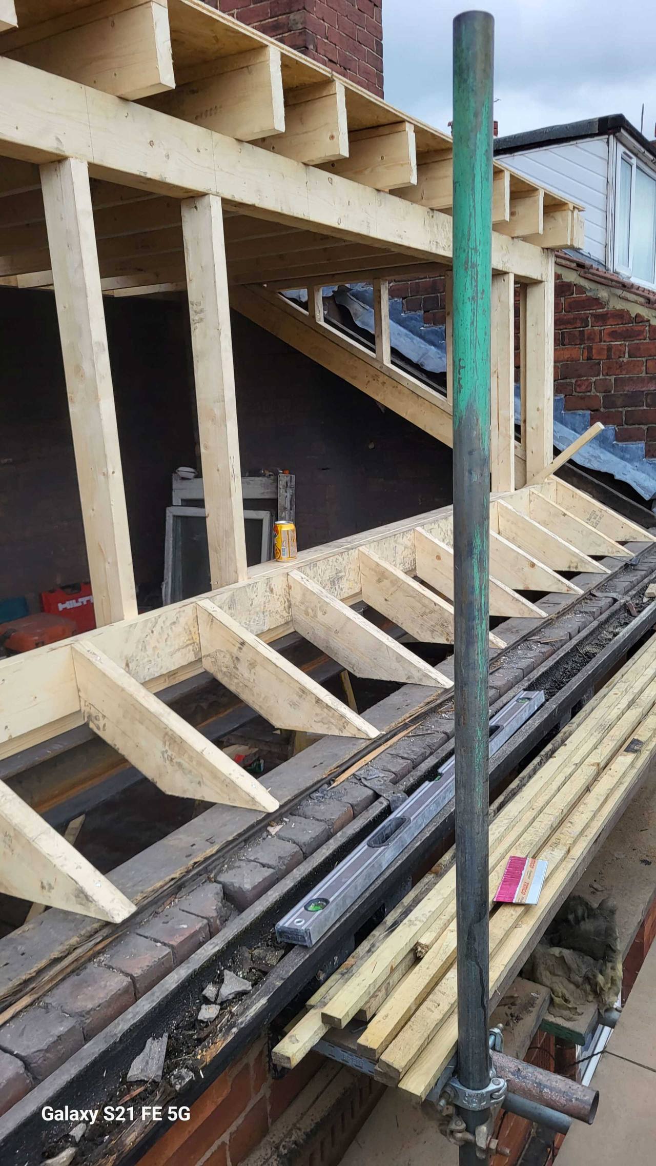 Timber dormer frame and new rafters rising from the existing brickwork during a loft conversion