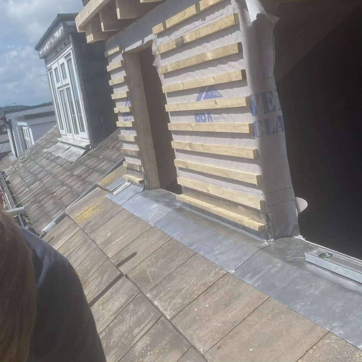 Dormer cheeks battened and wrapped in breathable membrane, with new lead flashing along the roof slope of a loft conversion